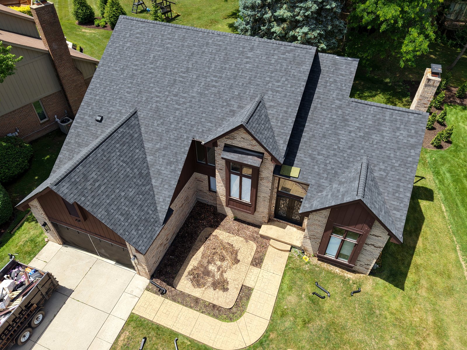 Get-R-Done Roofing completed project in Farmington Hills, Michigan — drone aerial view of finished architectural shingle roof on multi-gable brick home