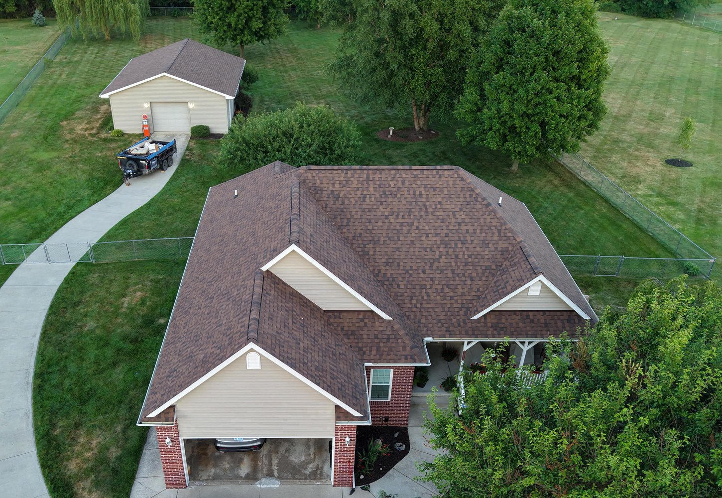 Get-R-Done Roofing completed project in Clio, Michigan — drone view of new architectural shingle roof on ranch home with crew trucks on site